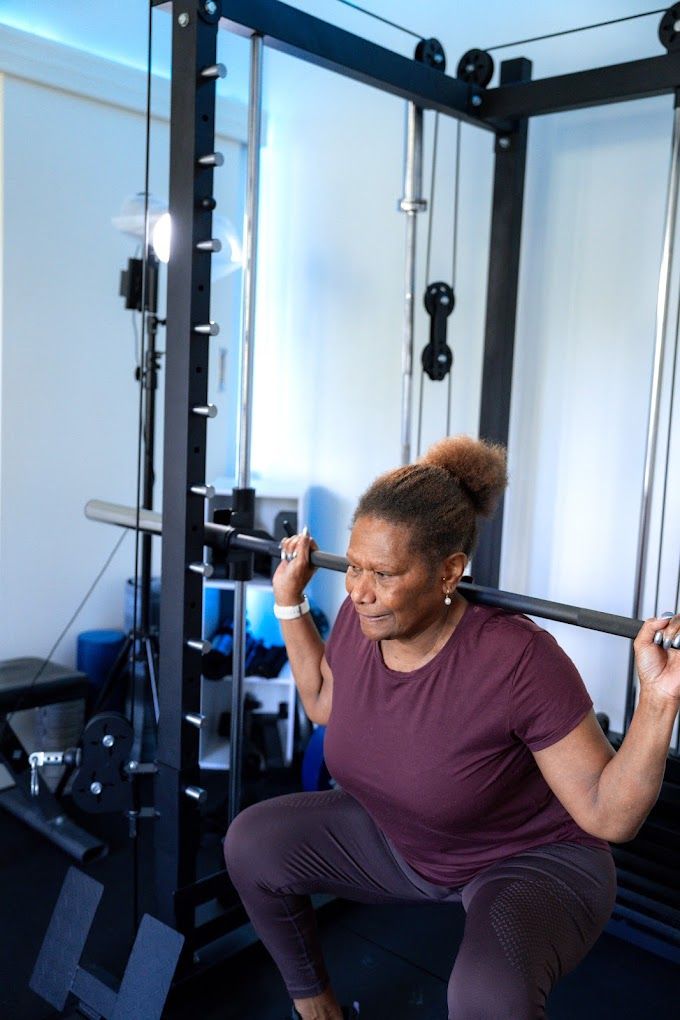 A client in her fifties smiling during a balance exercise